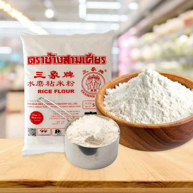 Baking essentials featuring a bag of Erawan Rice Flour on the left, a large wooden bowl of flour on the right, and a measuring scoop in the foreground.