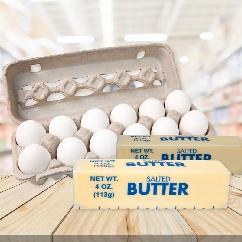 Dairy and fresh produce featuring a carton of white eggs in the back and two stacked sticks of salted butter in the foreground.
