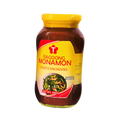 A glass jar filled with salted anchovies, prominently displayed on a black backdrop.