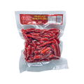 A bag of vibrant red chilli displayed against a solid black background.
