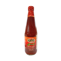 A hot sauce bottle featuring a bold label, isolated on a dark black background for emphasis.